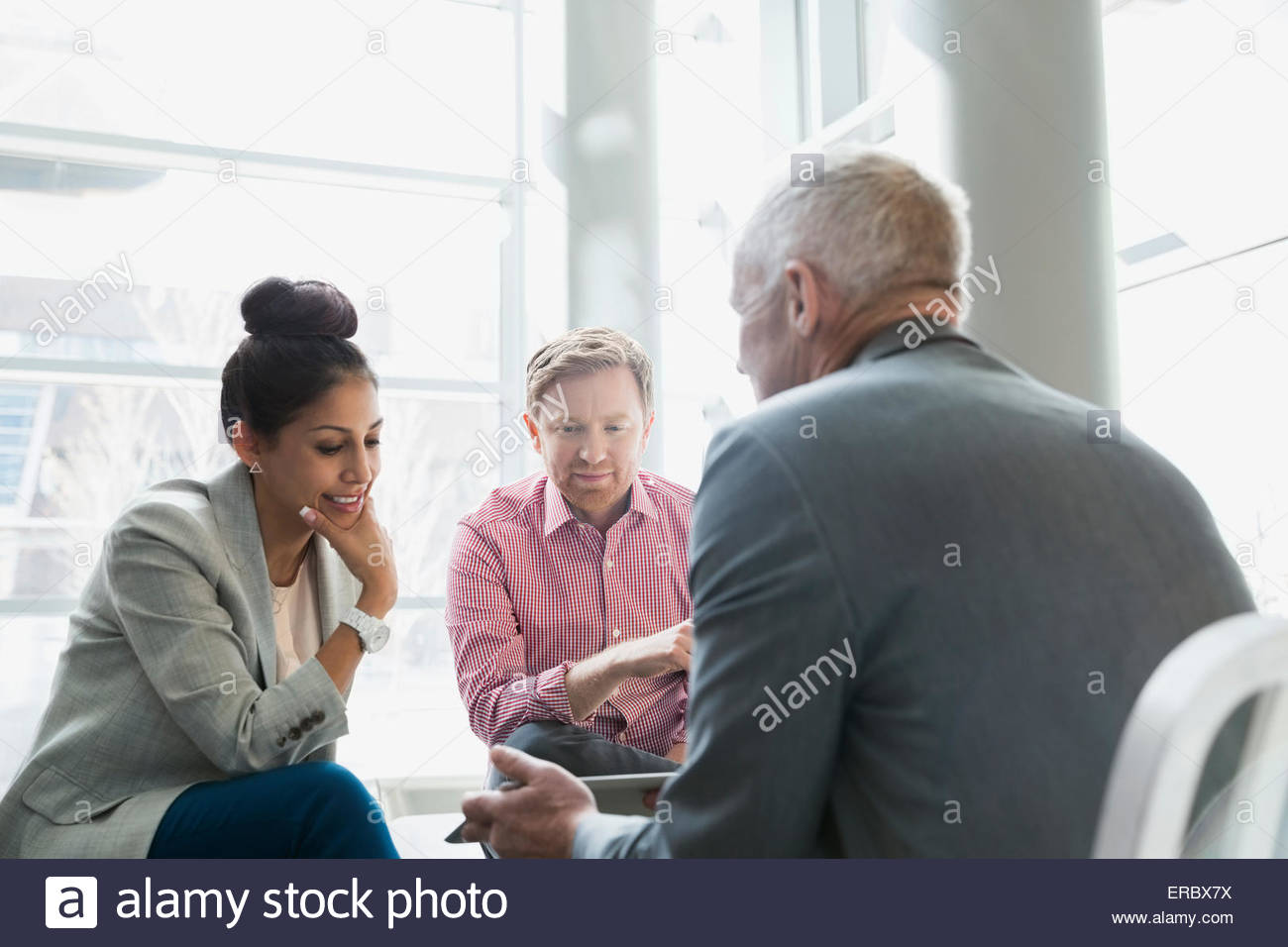 Business people using digital tablet in lobby Stock Photo