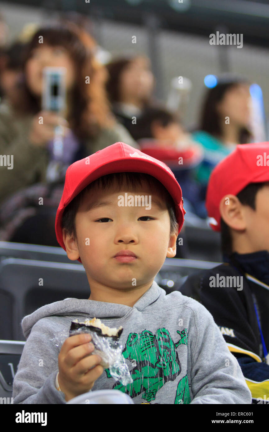 A young boy watches a game of the Nippon Ham Fighters baseball team at