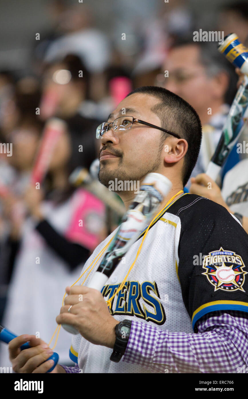 A Japanese man watches a game of the Nippon Ham Fighters baseball team