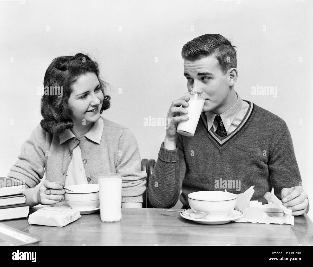 1940s Teenage Girl And Boy Eating School Lunch Soup Sandwiches Together Boy Drinking Milk 1940s Teenage Girl And Boy Eating School Lunch Soup Sandwiches Together Boy Drinking Milk