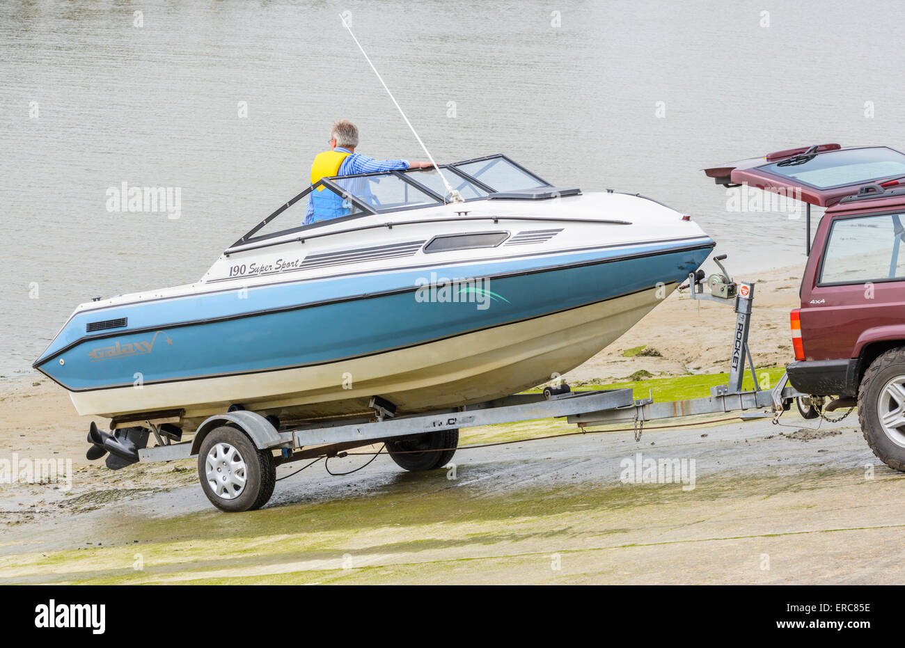 Boat on a trailer being launched into a river on a slipway. Stock Photo