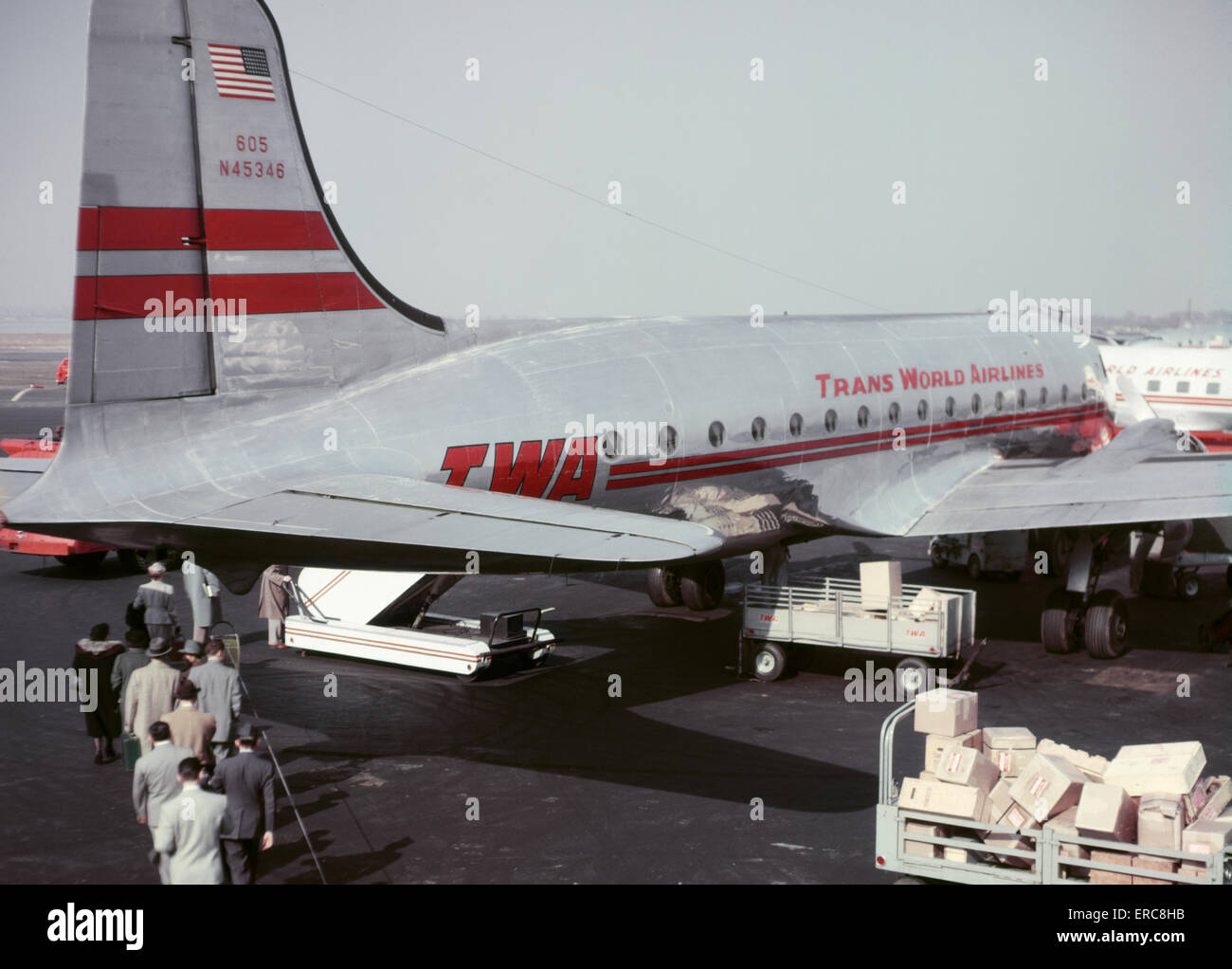1950s ANONYMOUS PASSENGERS AND CARGO ON TARMAC BOARDING TRANS WORLD AIRLINES TWA PLANE LAGUARDIA AIRPORT NEW YORK USA Stock Photo