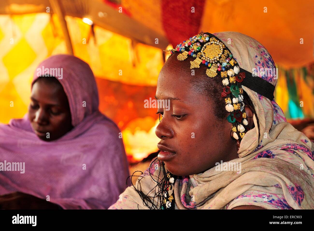 Two women, one with headdress, in a tent, Chinguetti, Adrar Region, Mauritania Stock Photo