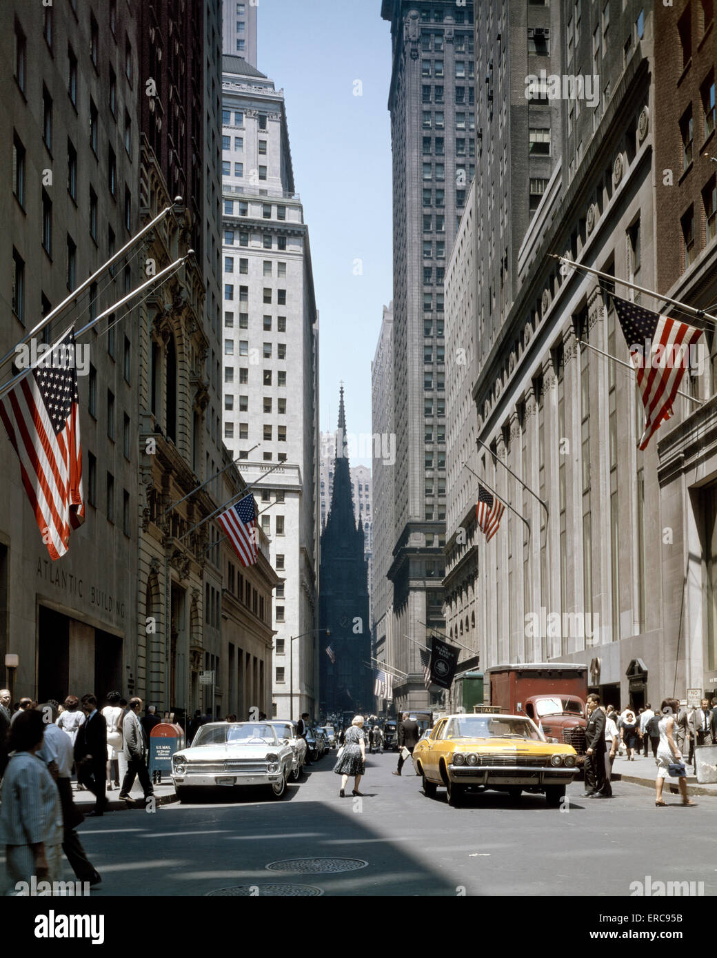 1960s VIEW DOWN WALL STREET TO TRINITY CHURCH DOWNTOWN MANHATTAN NEW YORK CITY USA Stock Photo