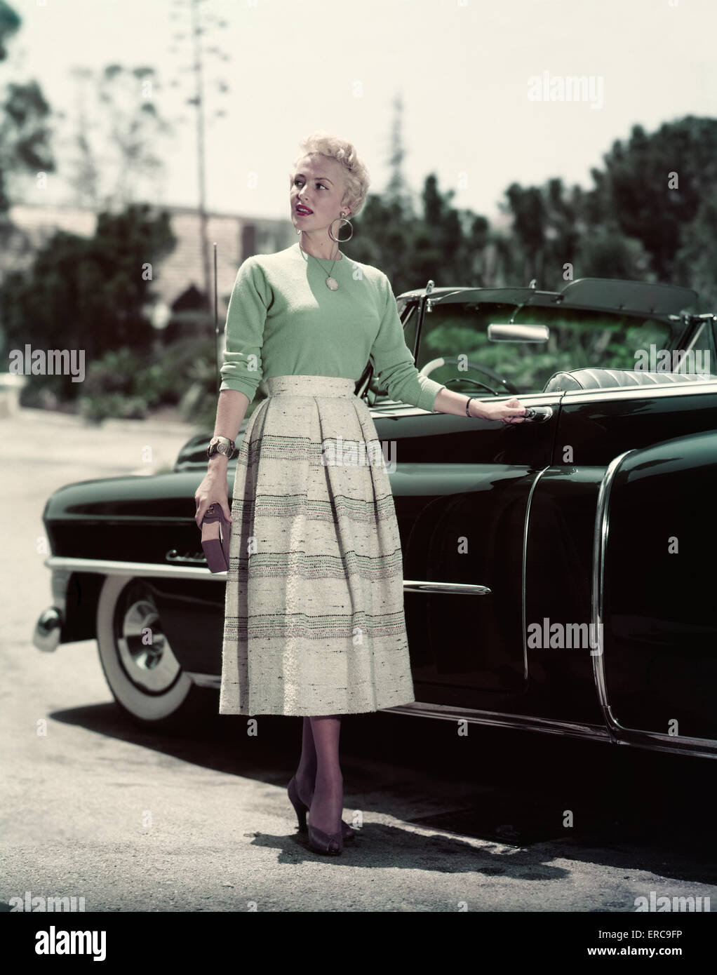 Female woman dressed in a rockabilly fashion posing next to a classic  vehicle Stock Photo - Alamy