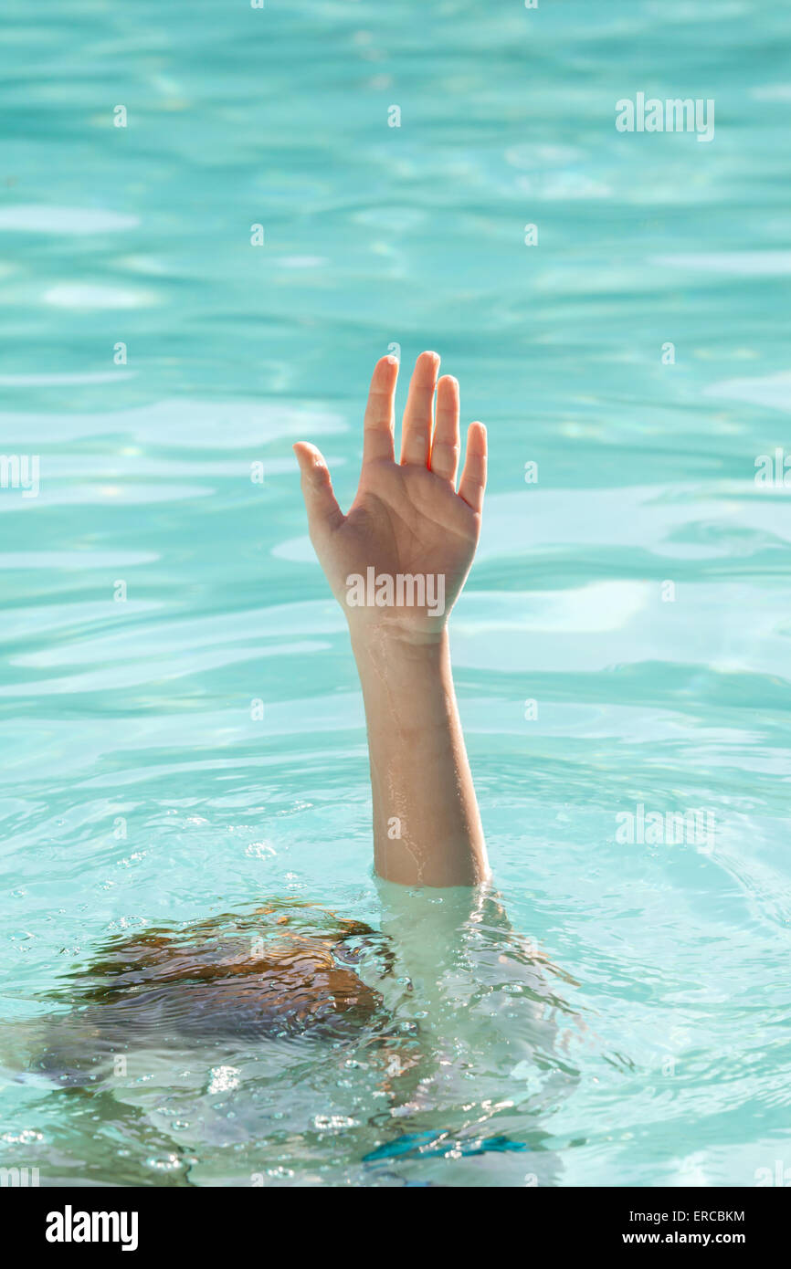 Hand of a drowning person stretching out of sea water pool and asking for help Stock Photo