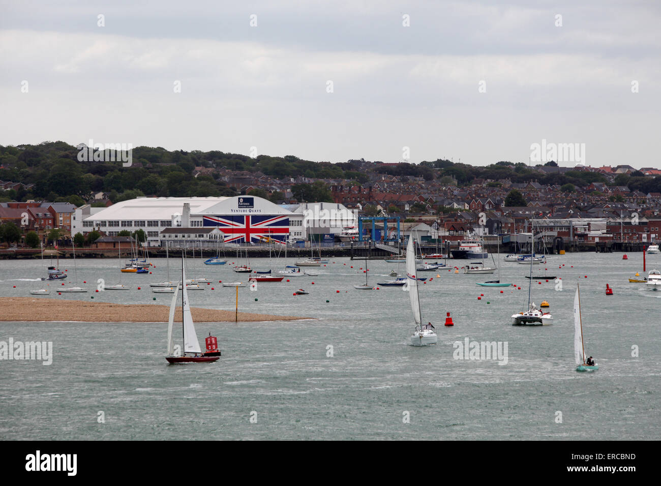 Yachts sail past Venture Quays in Cowes on the Isle of Wight which has the world's largest Union Flag painted on the doors Stock Photo