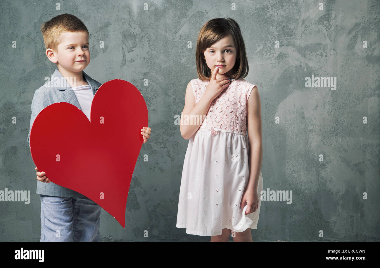 Cute little boy giving a heart to his cute sister Stock Photo