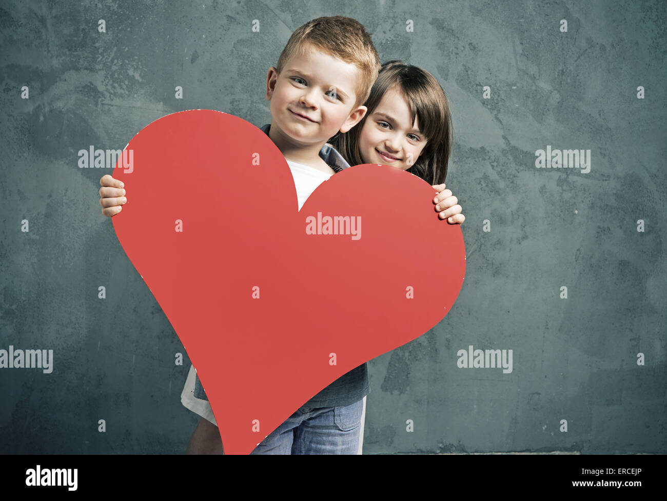 Boy and girl holding a paper heart Stock Photo - Alamy