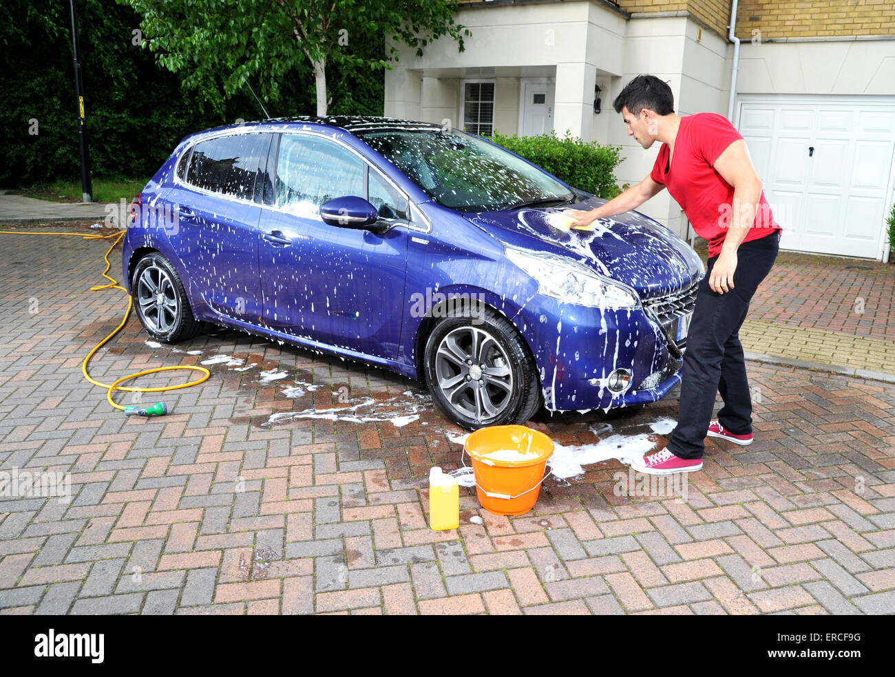 Young man washing a car Stock Photo Alamy