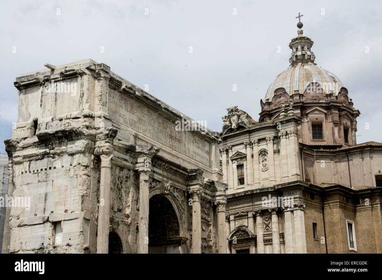 White marble Arch of Septimius Severus on the left and the Santi Luca e Martina church on the right background at the Roman forum. Stock Photo