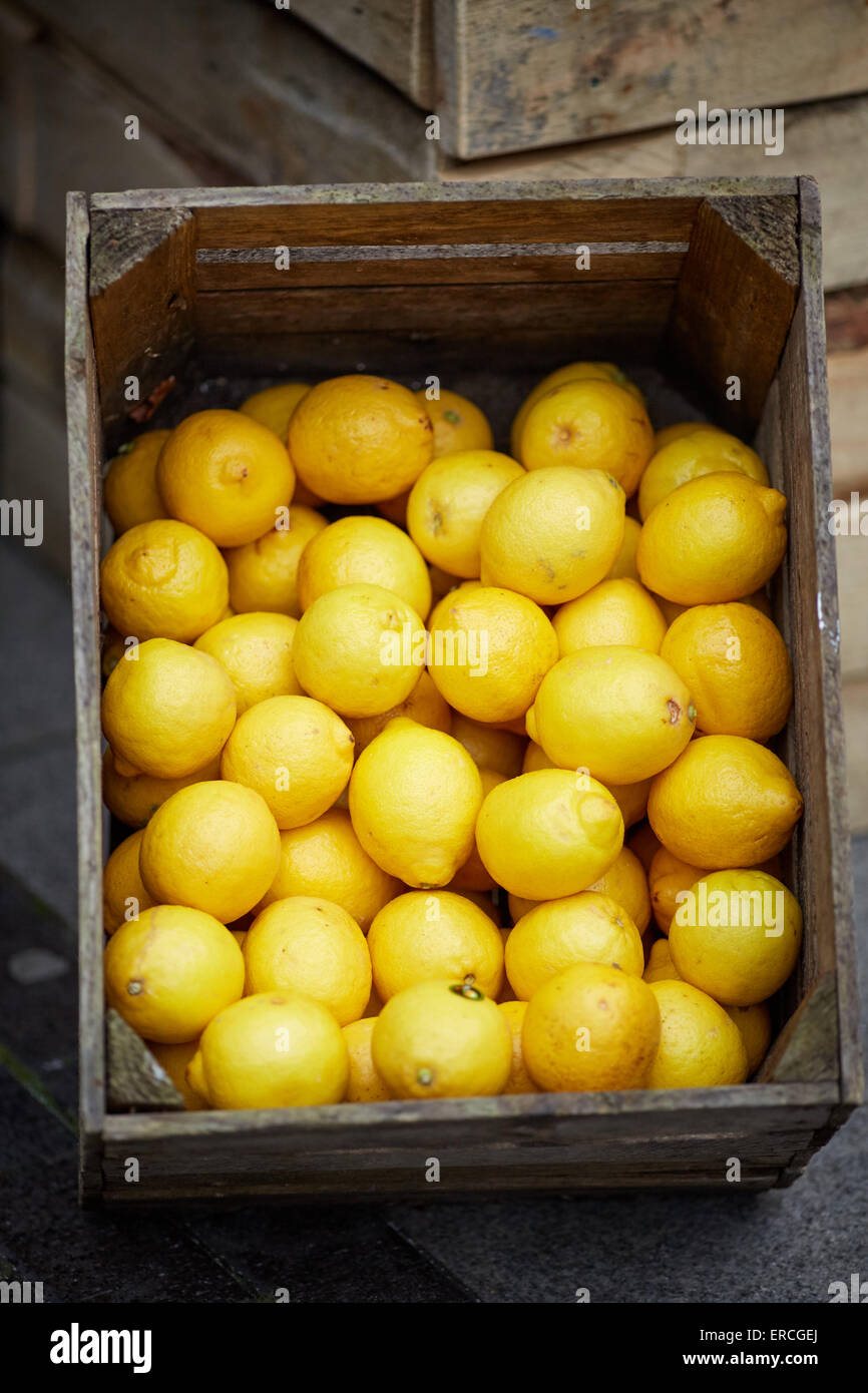 no packaging, on display, lifestyle, still life, set, displayed, display, Market stall food displayed in crated lose yellow fruit lemons Stock Photo