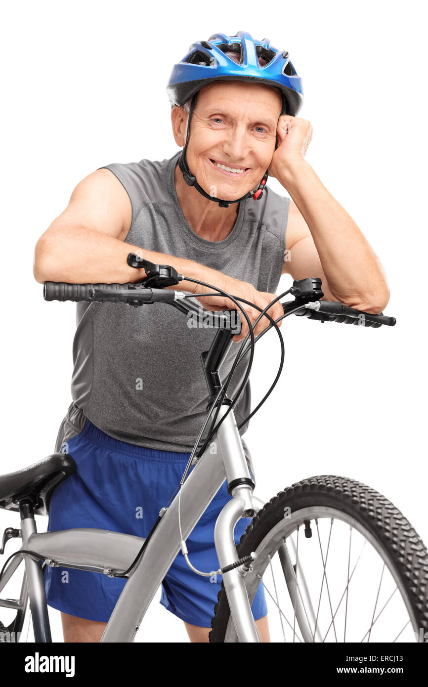 Vertical shot of a senior in sportswear leaning on a bicycle and posing isolated on white background Stock Photo