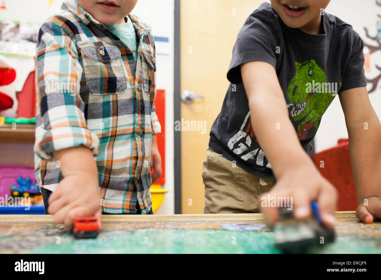 Two young boys play with toy cars. Stock Photo