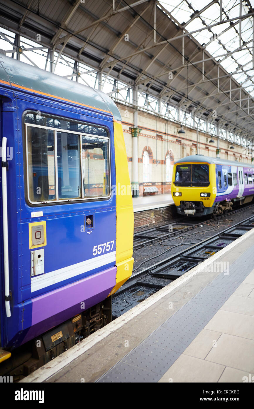 Manchester Piccadilly (left) a Norther Rail class 142 pacer   in the company's purple livery and a class 323 arriving   Railways Stock Photo