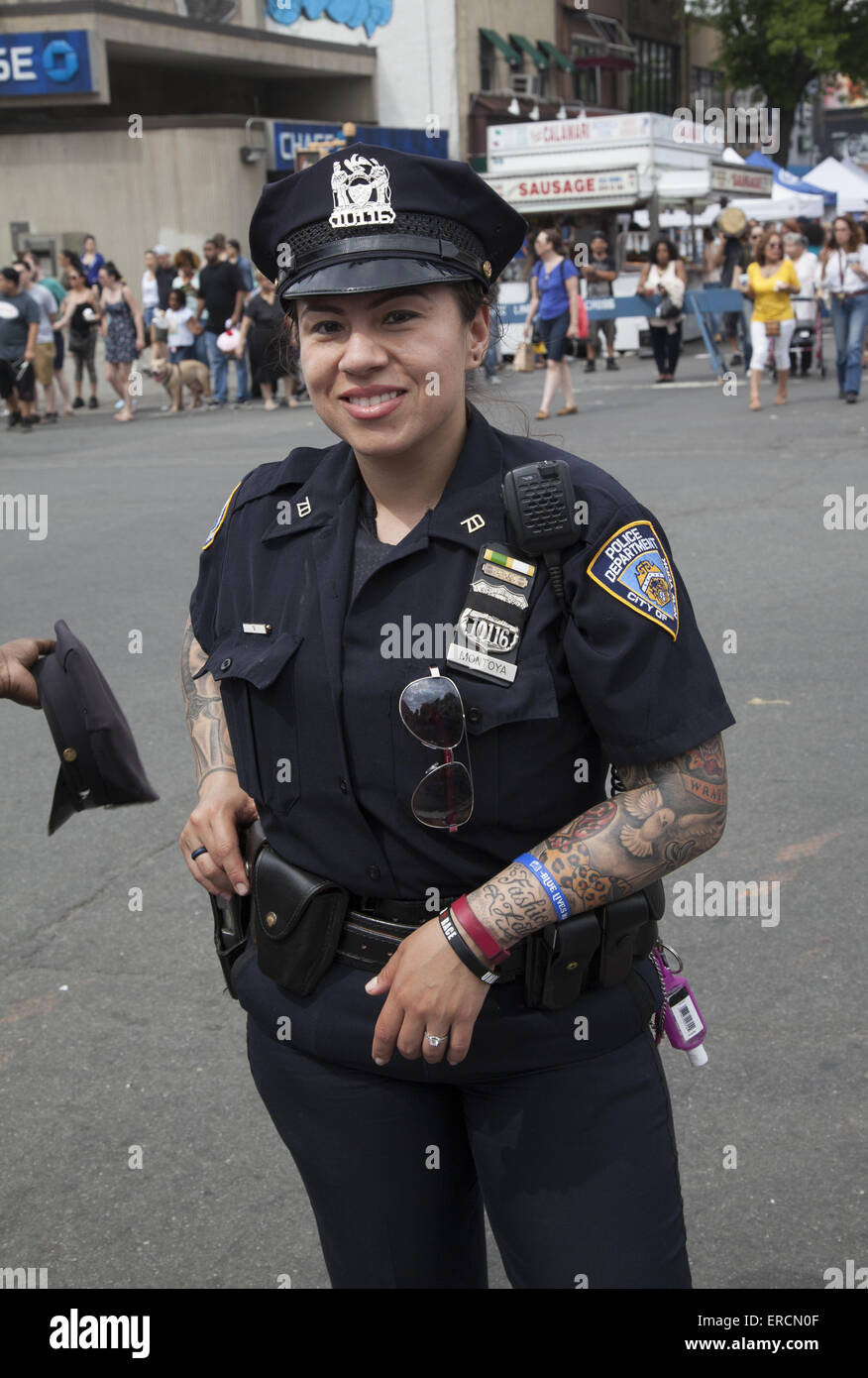 Female NYPD cop with tattoos showing down her arms on a warm spring day in Brooklyn, NY. Stock Photo