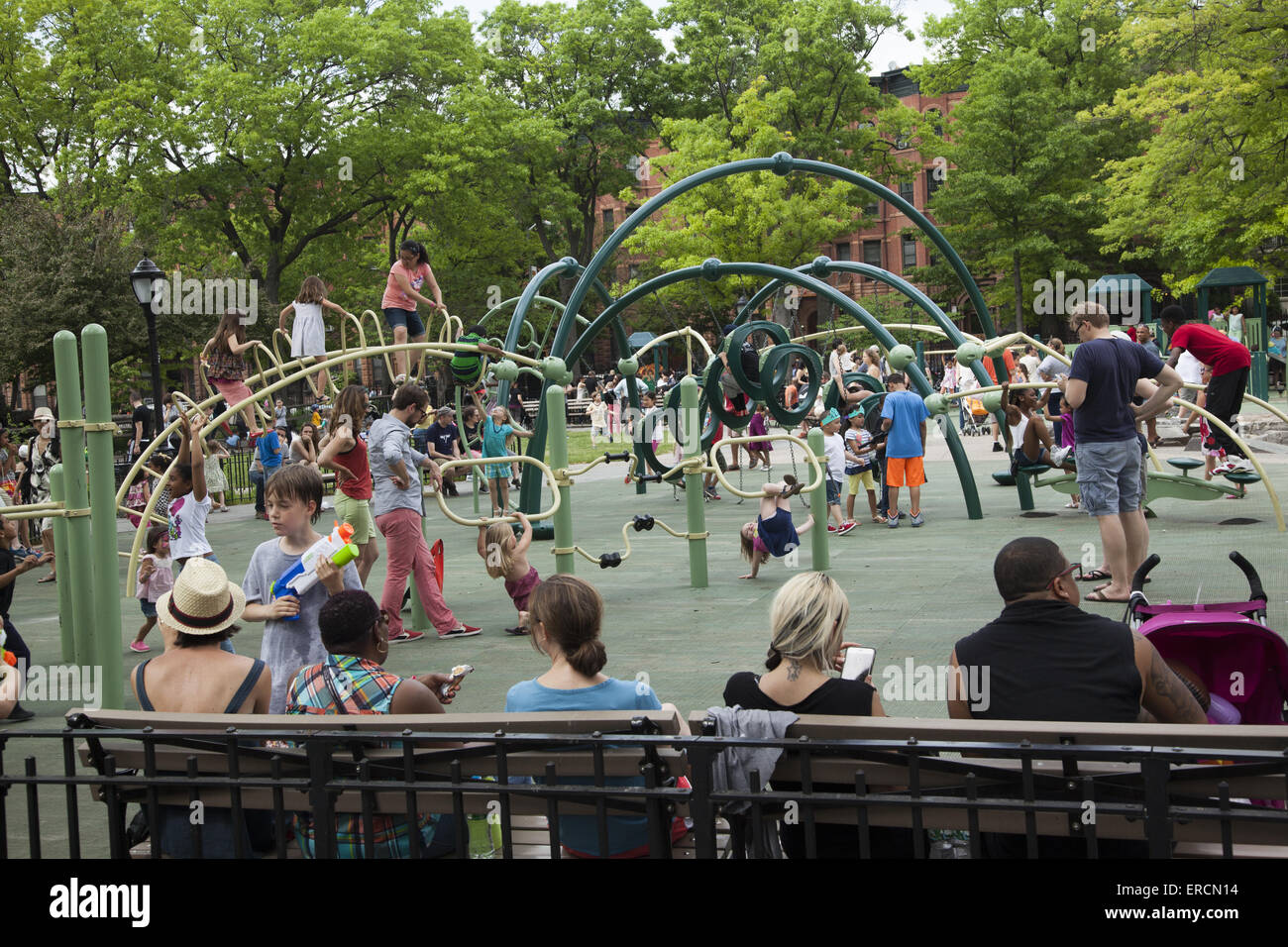 Neighborhood playground is crowded with families and kids on a warm spring day in Park Slope, Brooklyn, NY. Stock Photo