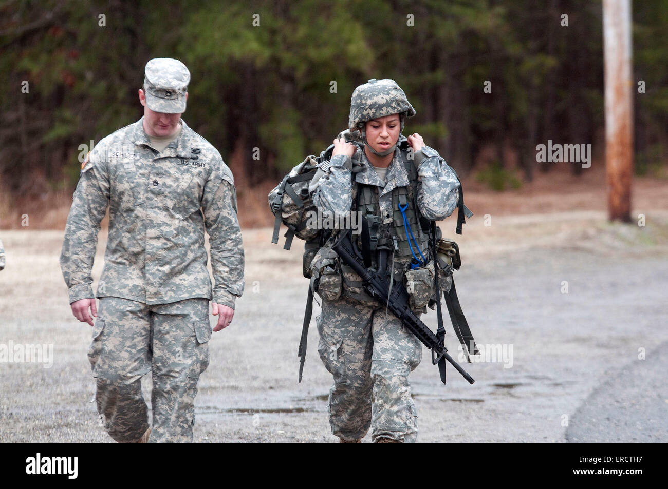 A Ranger instructor walks along with one of the first women candidates