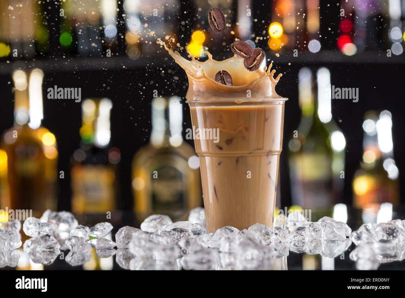 Cold coffee drink with ice, beans and splash, close-up. Stock Photo