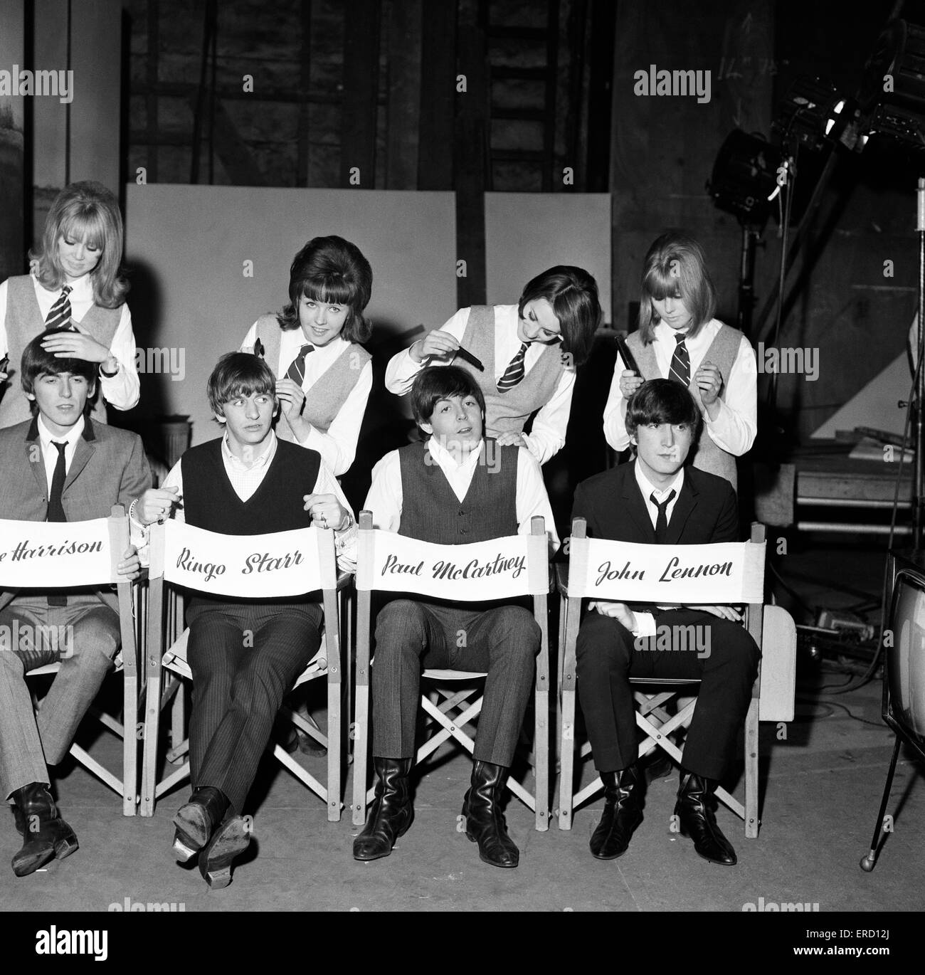 The Beatles being groomed at Twickenham Film Studios by Pattie Boyd and three A Hard Day's night extras, Tina Williams, Pru Bury and Susan Whitman, 12th March 1964. Left to right: George Harrison, Ringo Starr, Paul McCartney and John Lennon. Stock Photo
