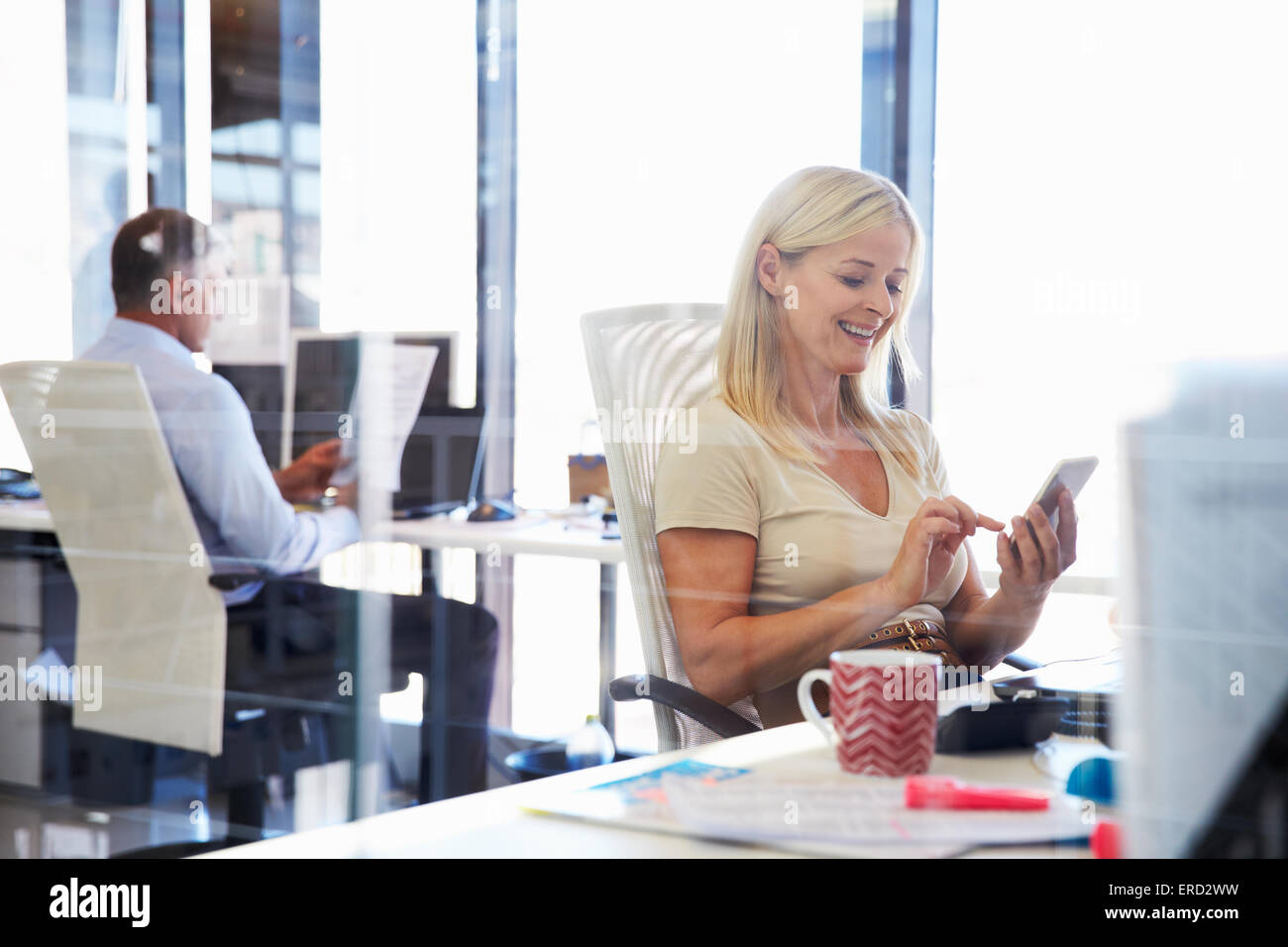 Woman using smart phone in an office Stock Photo