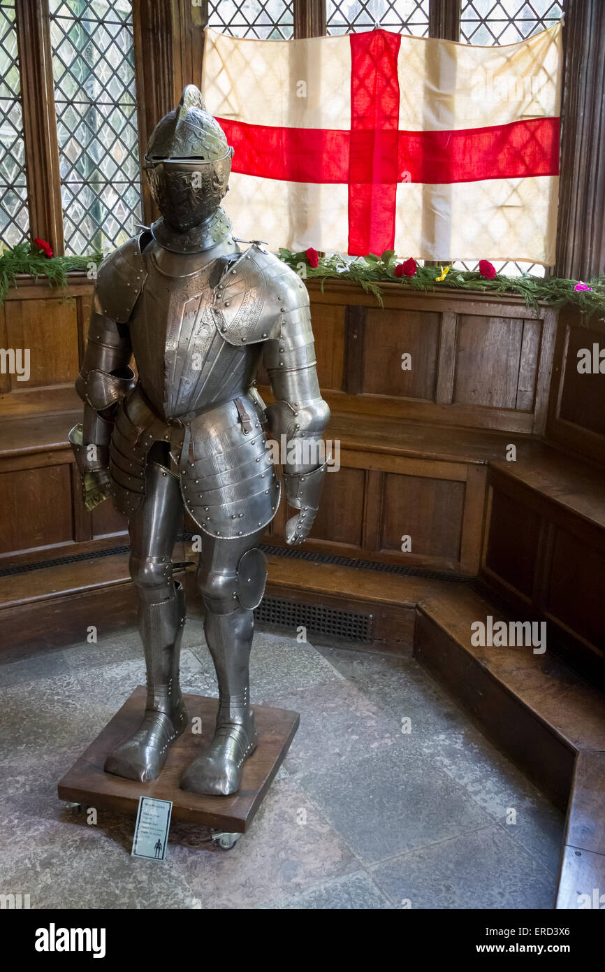 Suit of armour in front of a St George England Flag in the Great Hall at Speke Hall, Liverpool. Stock Photo