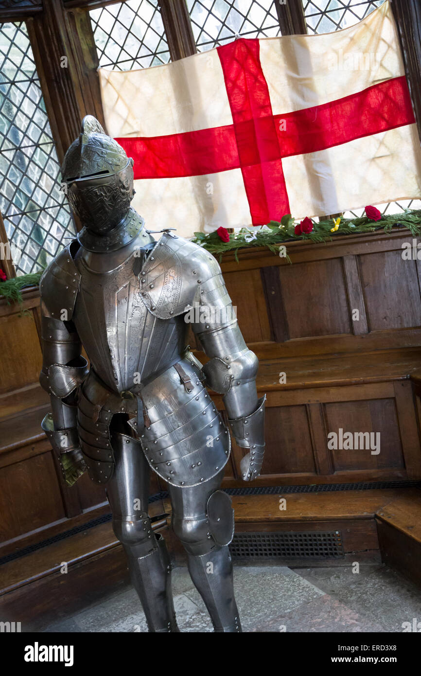 Suit of armour in front of a St George England Flag in the Great Hall at Speke Hall, Liverpool. Stock Photo
