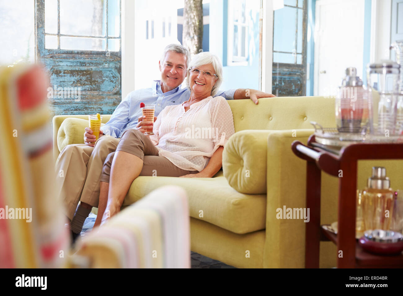 Senior Couple At Home Relaxing In Lounge With Cold Drinks Stock Photo ...