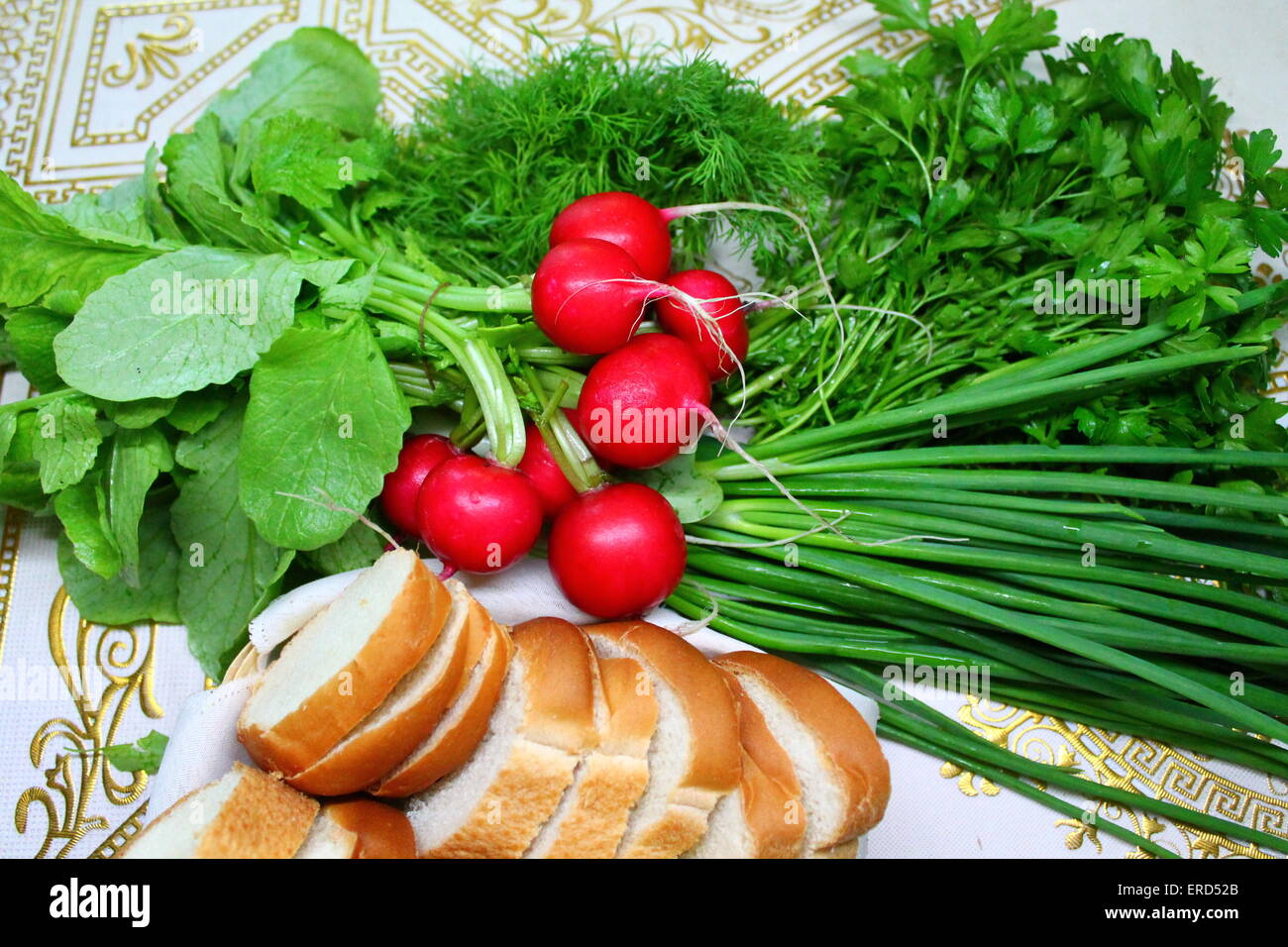 red ball shapes crust radish with leaves, green onion, tufts of aroma parsley and soft dill and piece of white bread Stock Photo