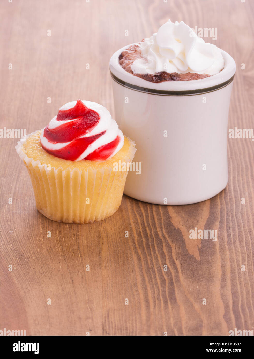 Strawberry cupcake with a cup of hot chocolate on dark wooden tabletop - anniversary or Valentine's treat to a loved one Stock Photo