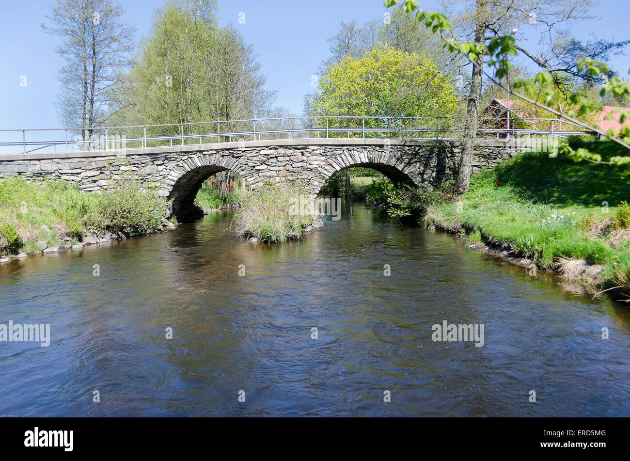 old stonebridge over the cold water one sunny day in early spring Stock Photo