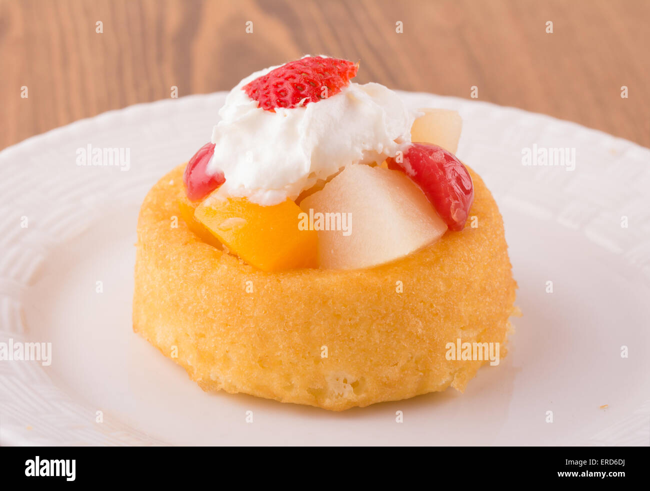 Dessert shell with fruit cocktail and whipped cream topping on a white plate Stock Photo