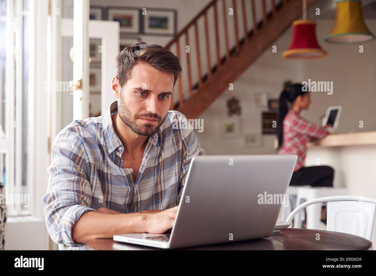 Young man using laptop in a cafe Stock Photo - Alamy