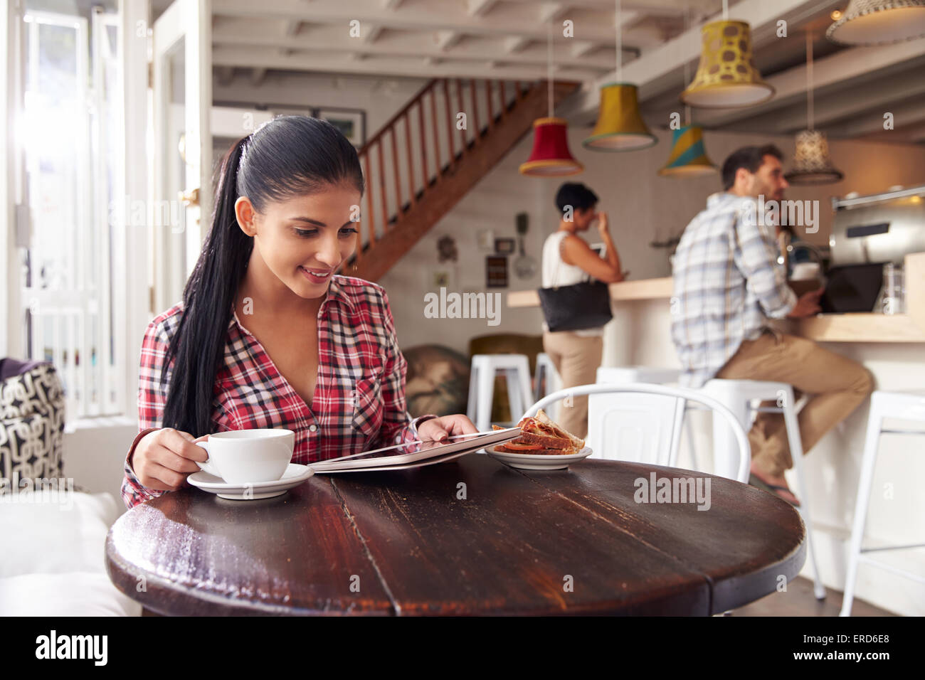 Young woman using laptop in a cafe Stock Photo - Alamy