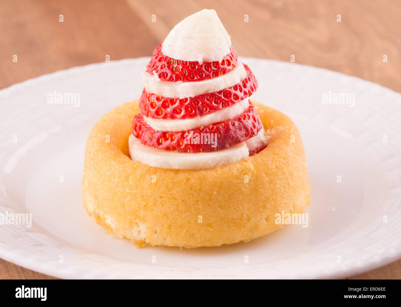 Dessert shell with sliced banana and strawberry on a white plate Stock Photo