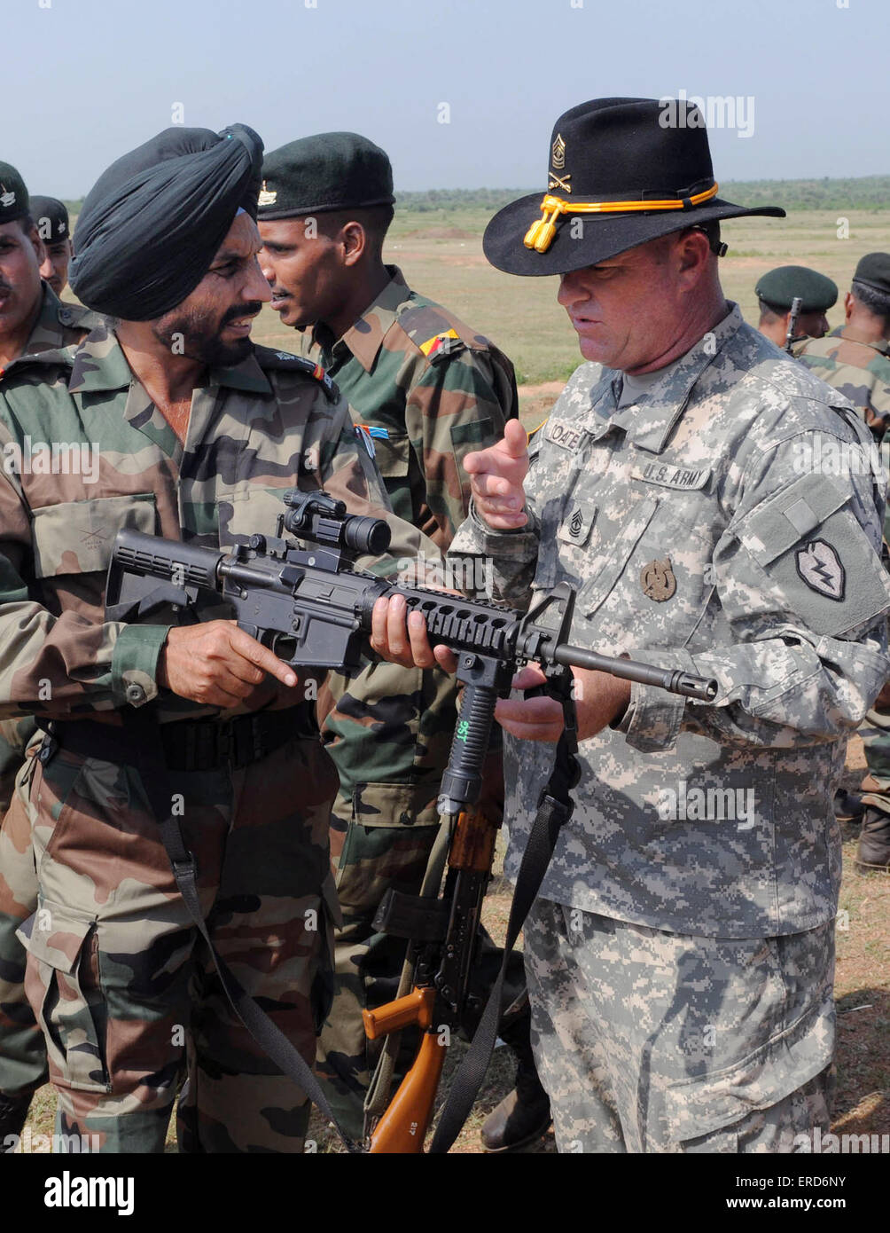 US Army 1st Sgt. Anthony Coates discusses the M4 carbine rifle with Indian Army Soldiers from the 94th Armored Brigade standing during Exercise Yudh Abhyas October 12, 2009 in Babina, India. Stock Photo