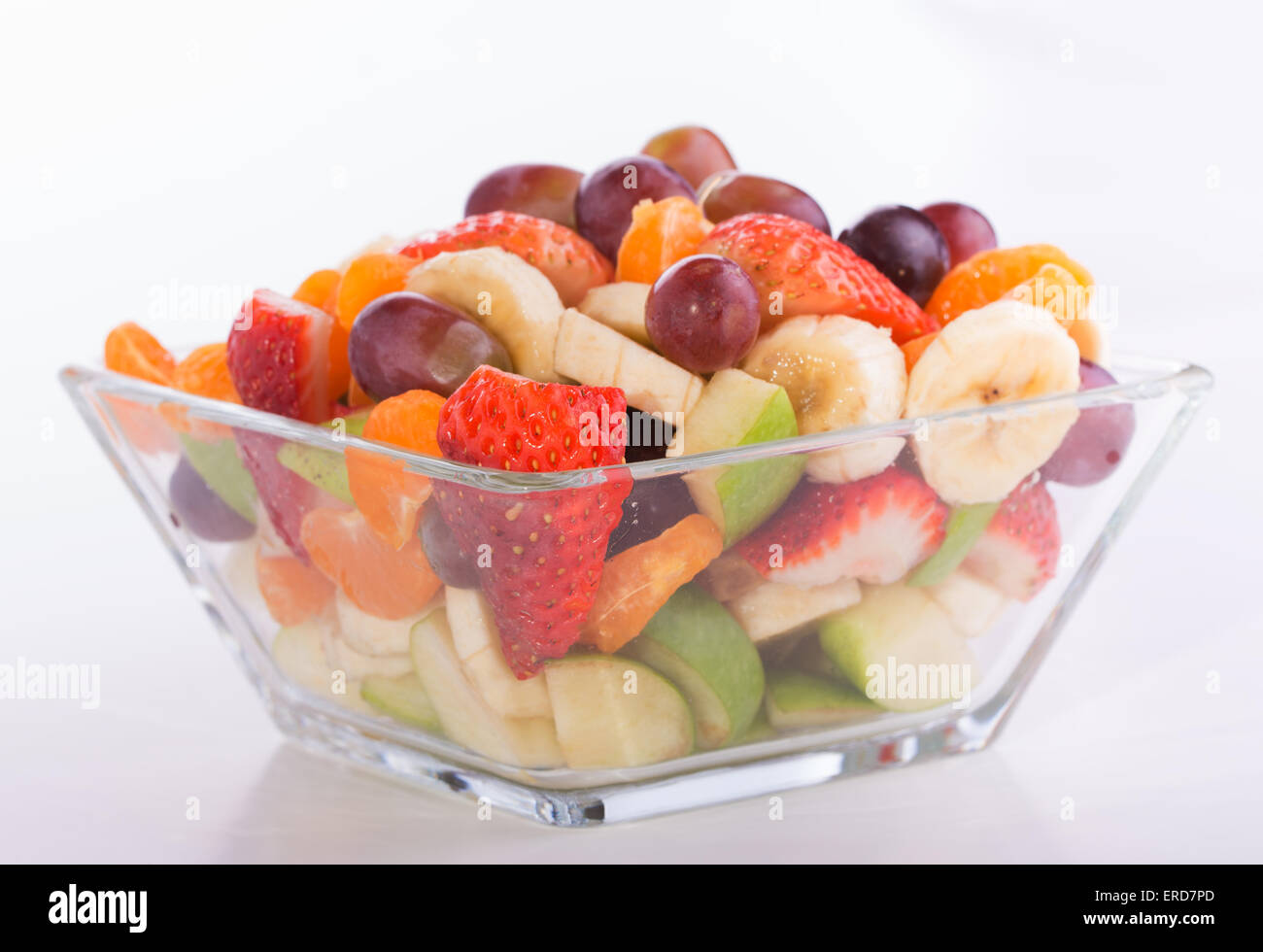 Fruit salad in rich colors in a glass bowl, on light background Stock ...