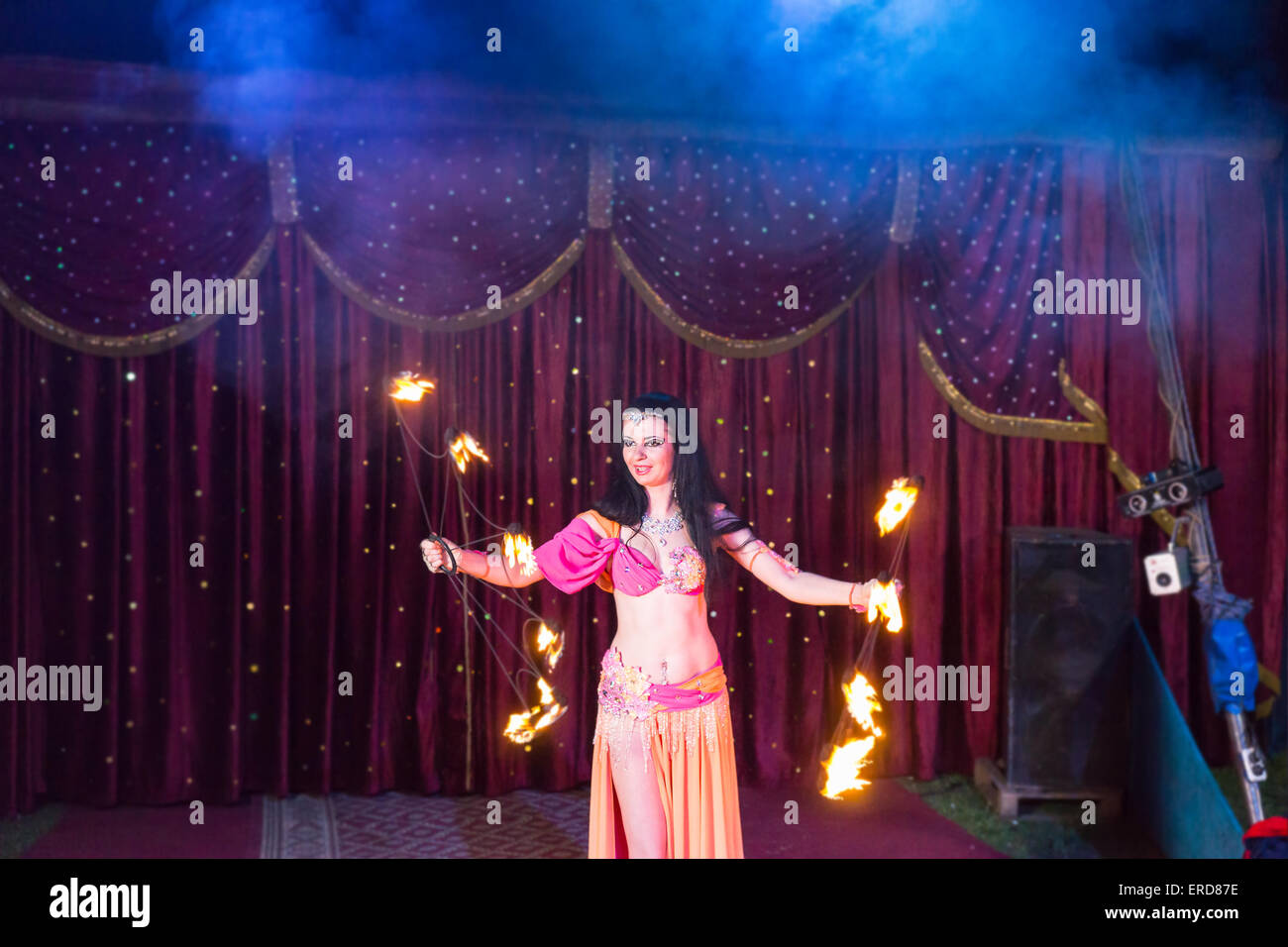 Exotic Dark Haired Female Fire Dancer Wearing Bright Pink and Orange