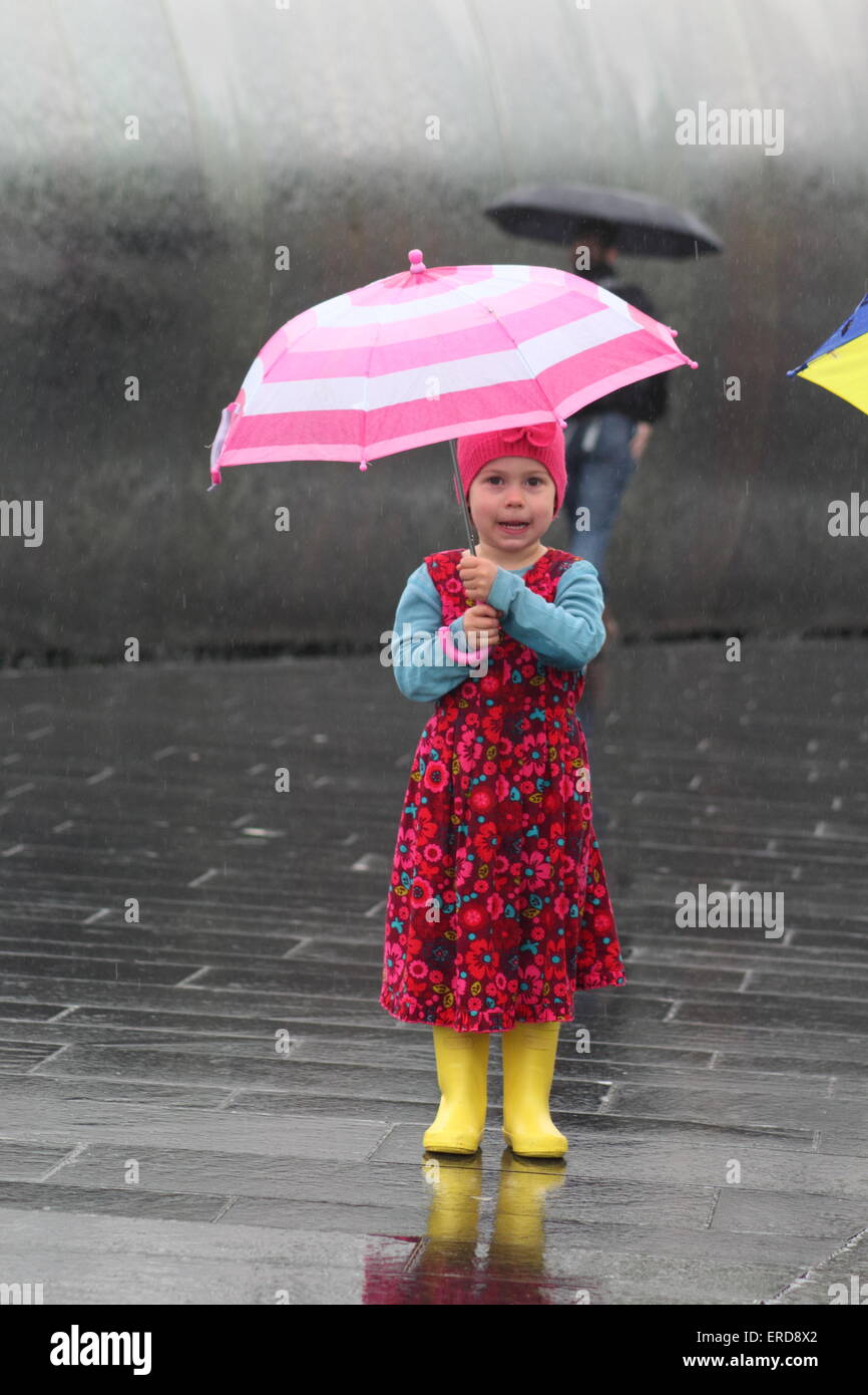 A young girl shelters under an umbrella during heavy rainfall in Sheffield South Yorkshire England UK Stock Photo