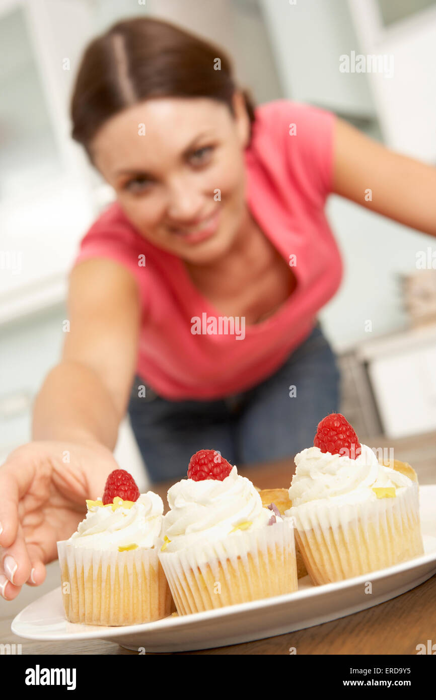 Woman Eating Cakes In Kitchen Stock Photo Alamy