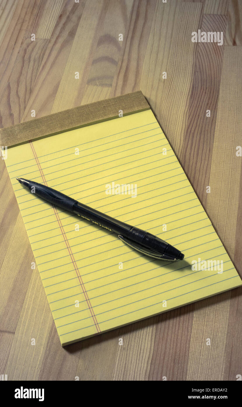 A small lined yellow legal pad and ball-point pen Stock Photo
