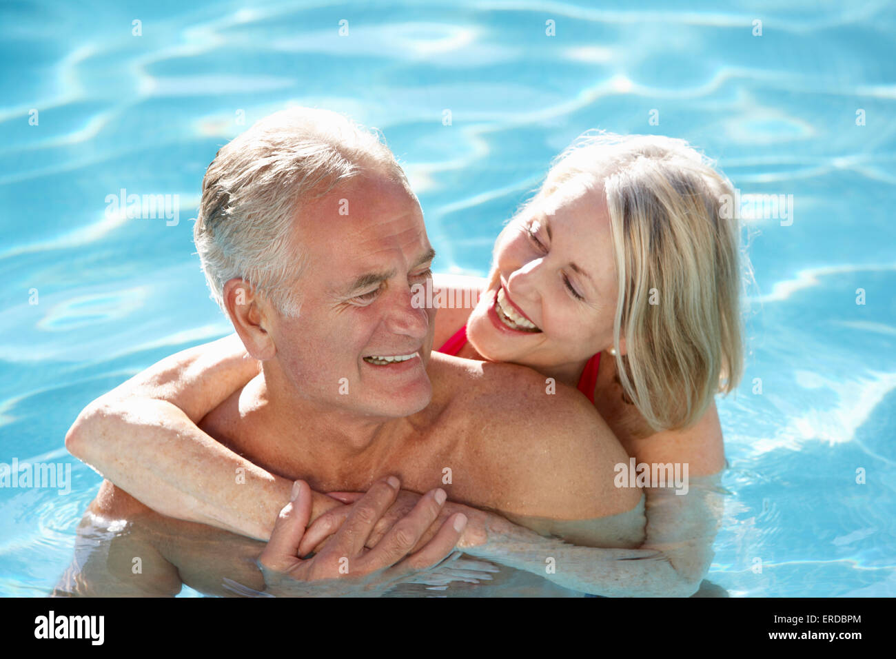 Senior Couple Relaxing In Swimming Pool Together Stock Photo - Alamy