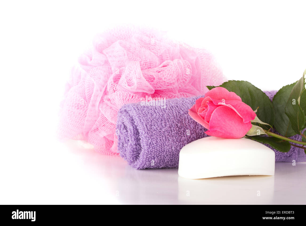 Wash cloth, shower puff, soap and pink rose on light background Stock Photo