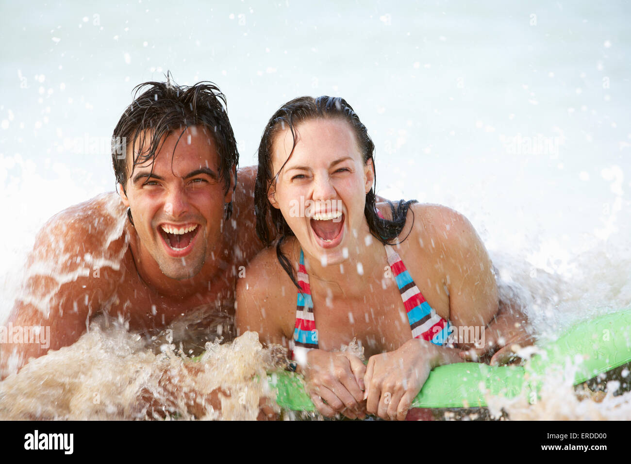 Young Couple Having Fun In Sea On Airbed Stock Photo