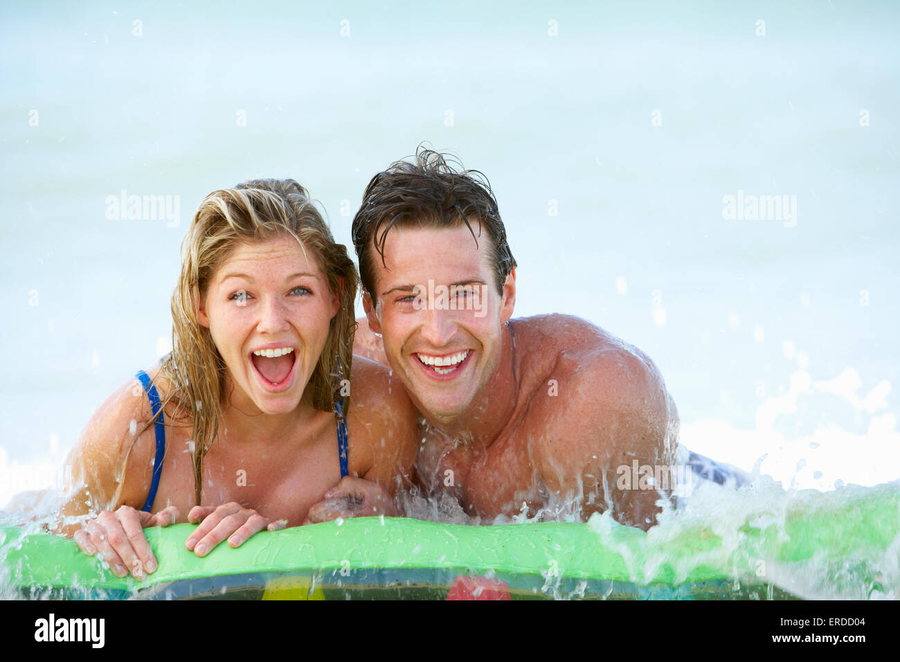 Young Couple Having Fun In Sea On Airbed Stock Photo