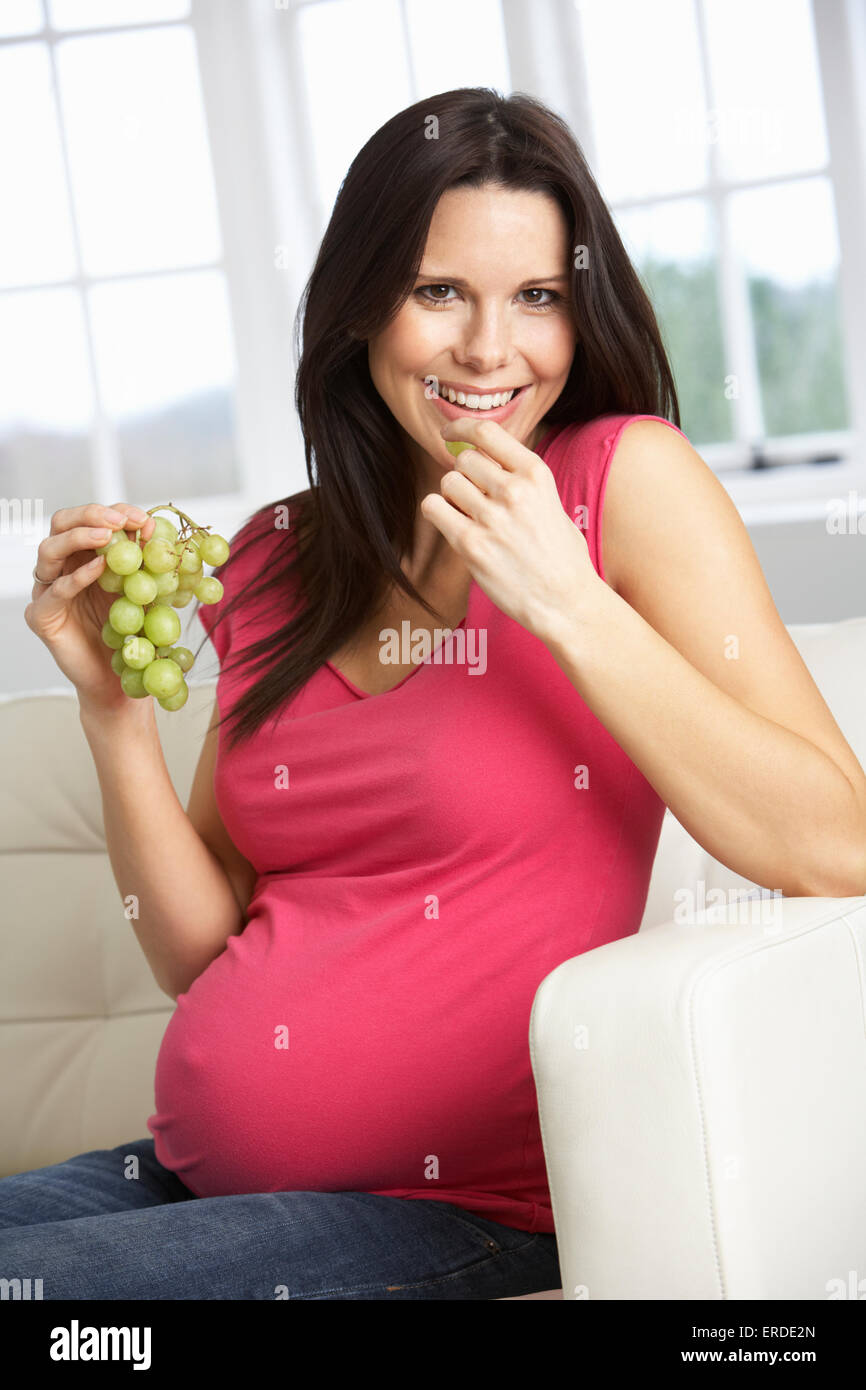 Pregnant Woman Eating Grapes Sitting On Sofa At Home Stock Photo Alamy