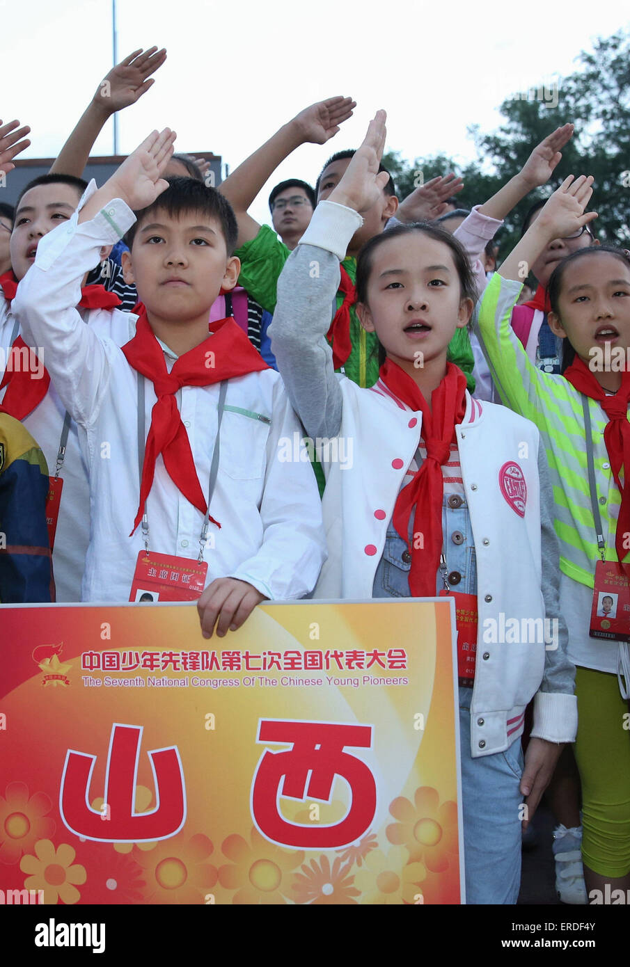 Beijing, China. 2nd June, 2015. Representatives attending the 7th National Congress of the Chinese Young Pioneers (CYP) raise hands in salute and sing national anthem as they watch national flag raising ceremony at the Tian'anmen Square in Beijing, capital of China, June 2, 2015. The 7th CYP National Congress was held here on Monday and Tuesday. © Wang Shen/Xinhua/Alamy Live News Stock Photo