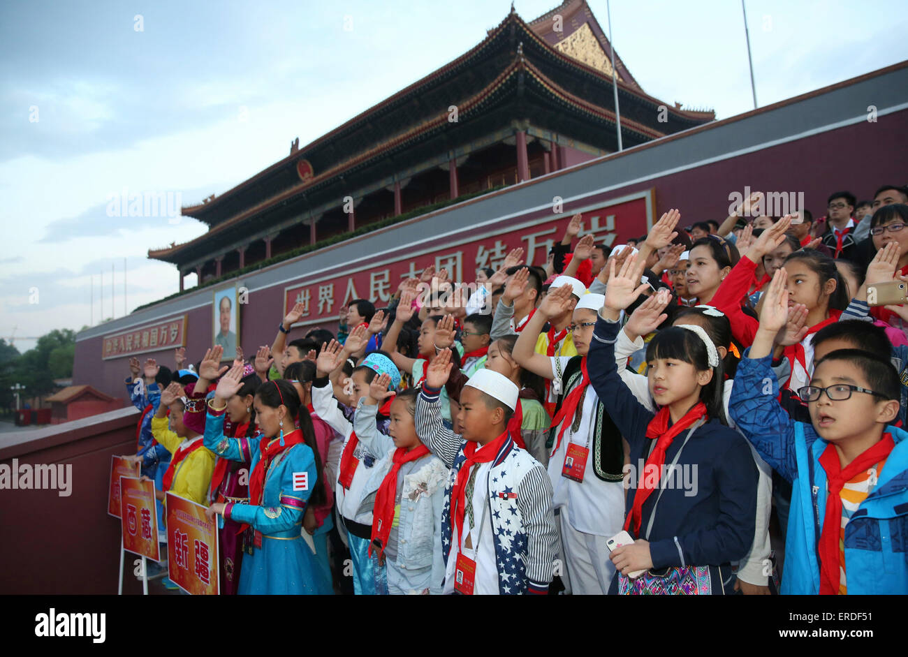 Beijing, China. 2nd June, 2015. Representatives attending the 7th National Congress of the Chinese Young Pioneers (CYP) raise hands in salute and sing national anthem as they watch national flag raising ceremony at the Tian'anmen Square in Beijing, capital of China, June 2, 2015. The 7th CYP National Congress was held here on Monday and Tuesday. © Wang Shen/Xinhua/Alamy Live News Stock Photo