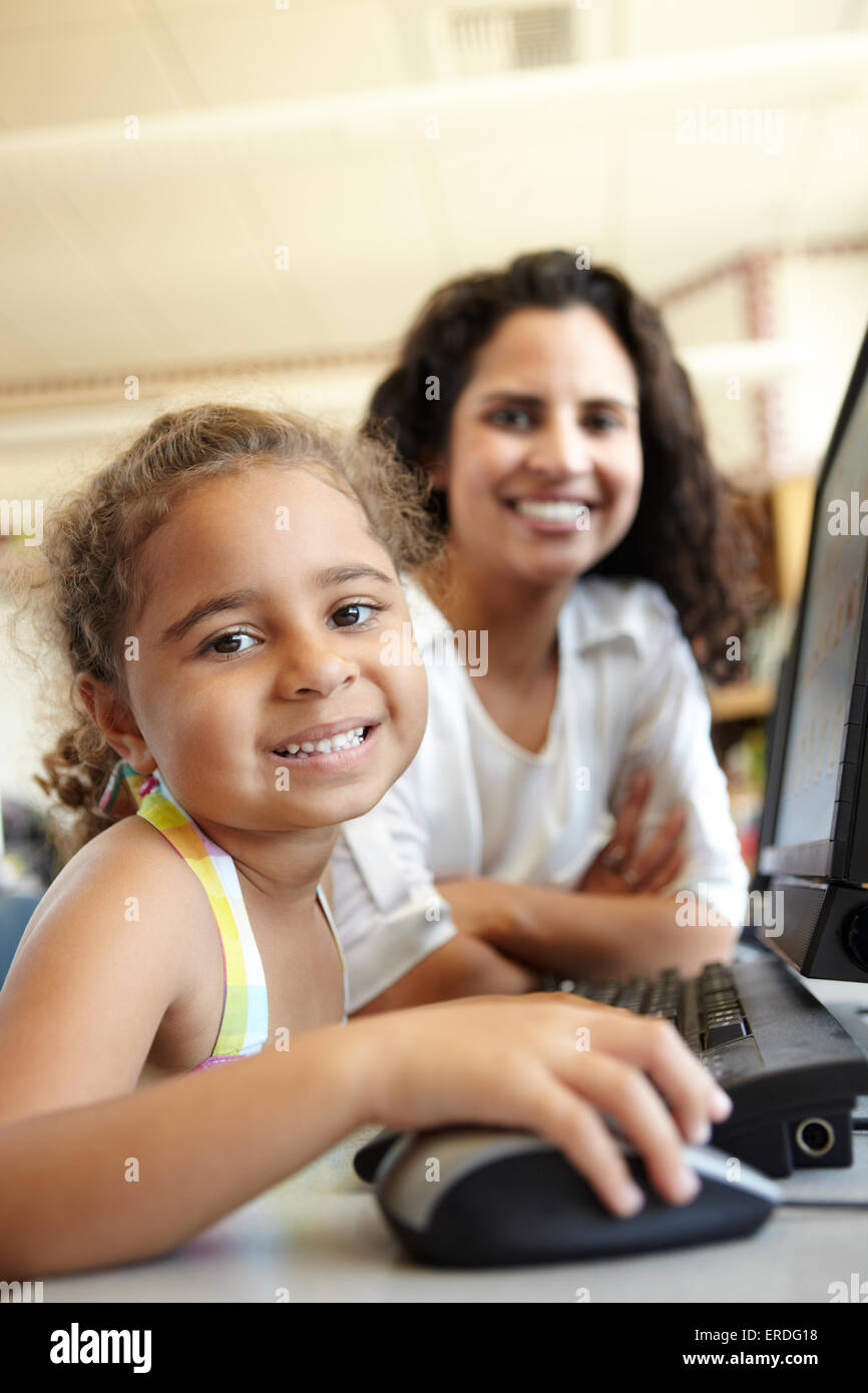 Elementary School Pupil With Teacher In Computer Class Stock Photo - Alamy