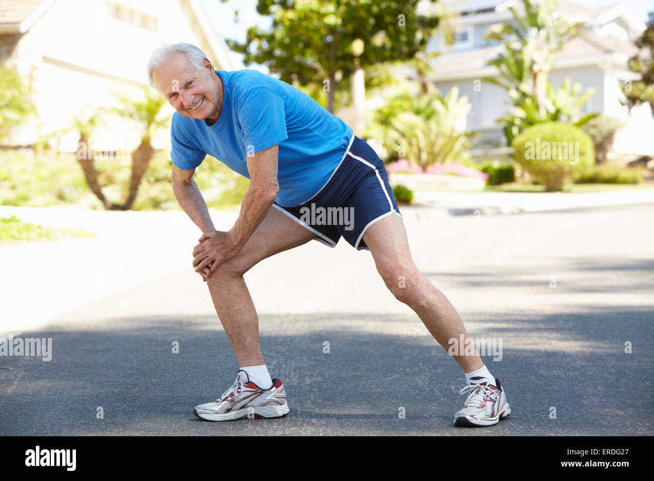 Elderly man warming up for run Stock Photo